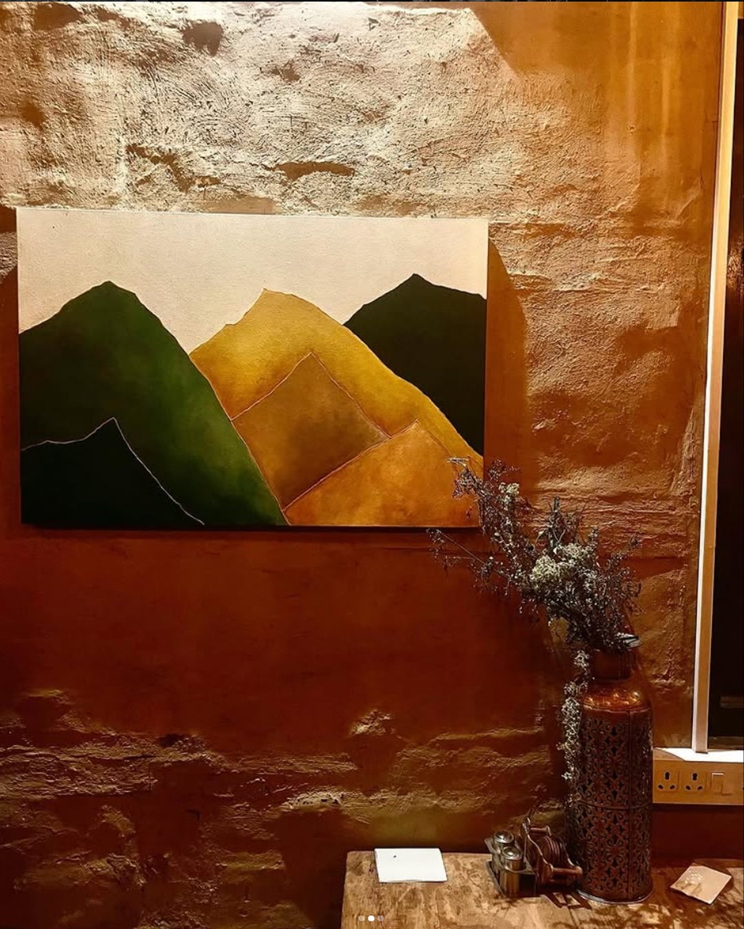 Mountain canvas hanging in a warmly lit room